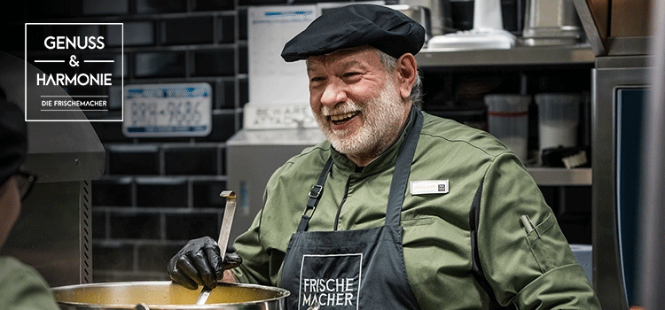 Koch in Arbeitskleidung für Unternehmen lächelt in der Küche