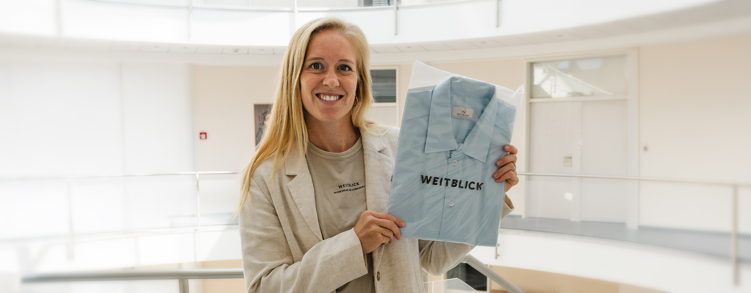 Frau hält Weitblick Arbeitskleidung in modernem Bürogebäude